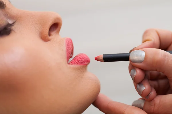 Mujer joven durante el tratamiento de maquillaje . — Foto de Stock