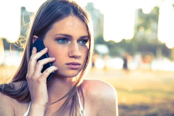 Dívka s Kobaltová modř telefon blízko pláže — Stock fotografie