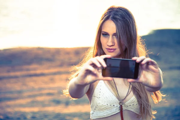 Dívka s Kobaltová modř telefon blízko pláže — Stock fotografie