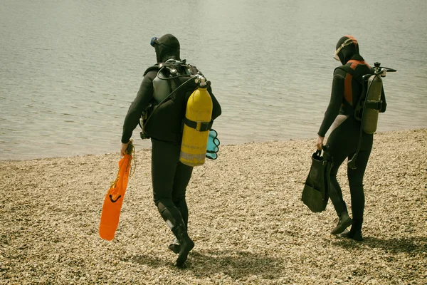 Paar trägt Taucherausrüstung im Wasser — Stockfoto