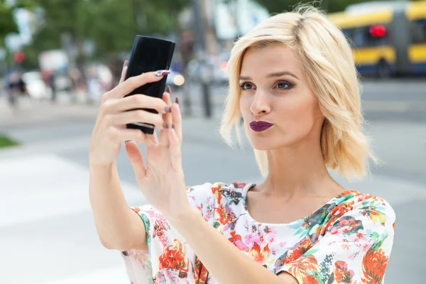 Ung kvinna talar en selfie — Stockfoto