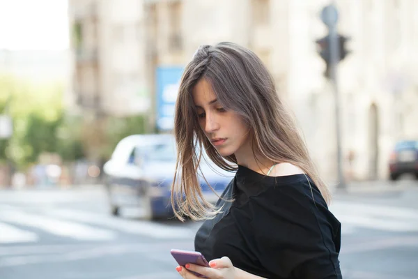 Frau checkt ihr Smartphone — Stockfoto