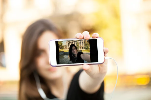 Junge Frau macht ein Foto mit ihrem Handy — Stockfoto