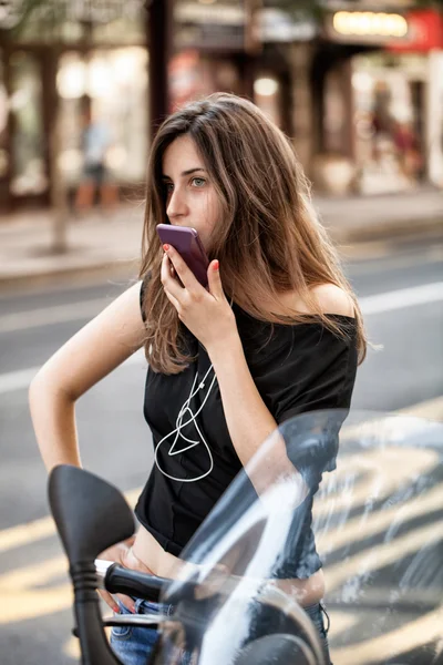 Femme avec smartphone sur moto — Photo