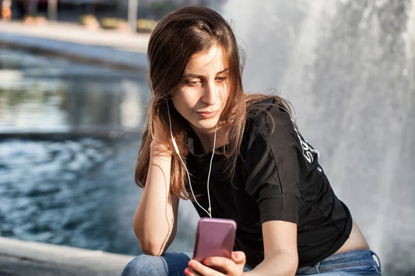 Jonge vrouw zit en haar muziek beluisteren — Stockfoto