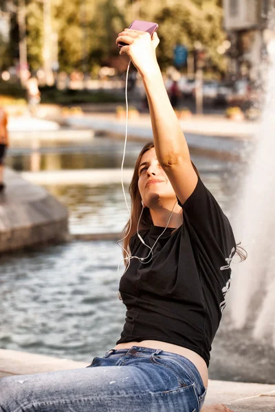 Frau sitzt und macht Selfie — Stockfoto