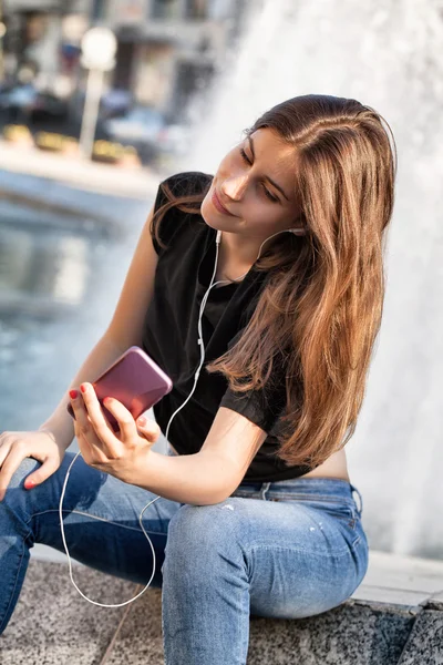 Mladá žena sedět a poslouchat její hudbu — Stock fotografie