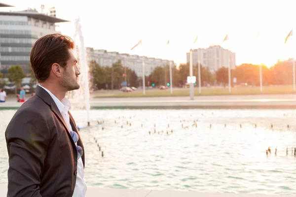 Hombre de negocios frente a una fuente — Foto de Stock