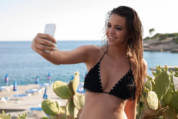 Kvinnan tar självporträtt på stranden — Stockfoto