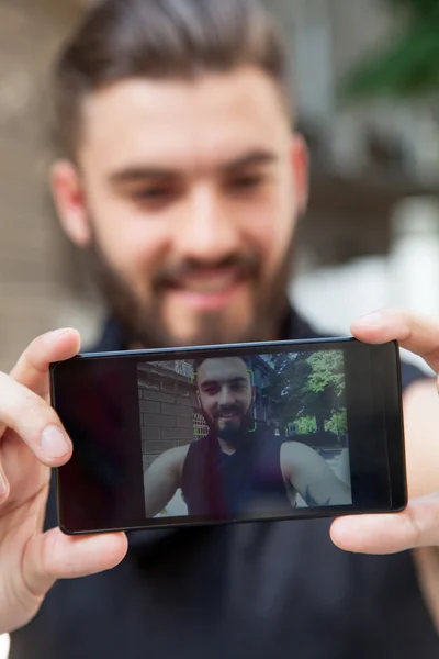 Lachende casual man neemt een selfie — Stockfoto