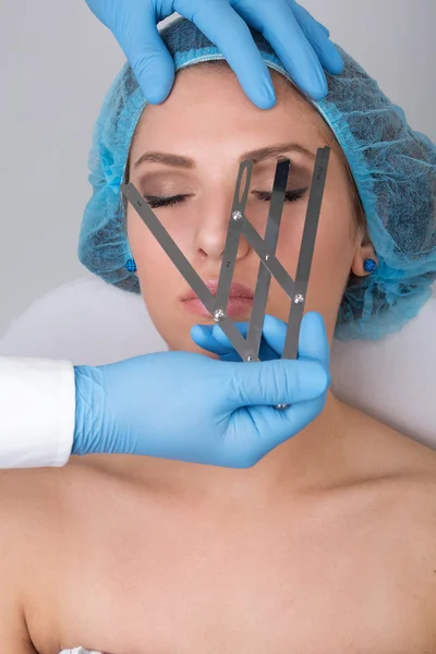 Mujer joven recibiendo un tratamiento permanente de maquillaje de cejas —  Fotos de Stock