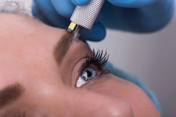 Ung kvinna att få en permanent ögonbryn make up behandling — Stockfoto