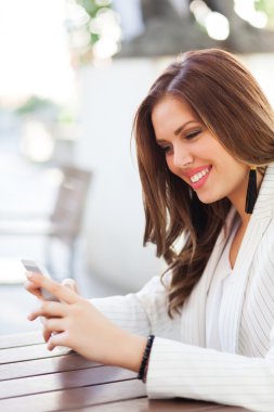 Bir cep telefonu kullanarak bir genç kadının portresi