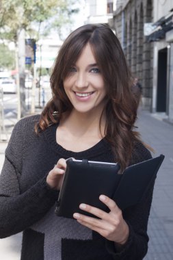 Sokakta bir tablet tutan genç kadın