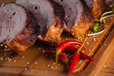 Lezzetli, sulu ve güzel kokulu domuz eti, siyah arka planda ahşap bir tahtada pirzola, acı kırmızı biber ve baharatlar. Lezzetli et konsepti