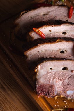 Lezzetli, sulu ve güzel kokulu domuz eti, siyah arka planda ahşap bir tahtada pirzola, acı kırmızı biber ve baharatlar. Lezzetli et konsepti