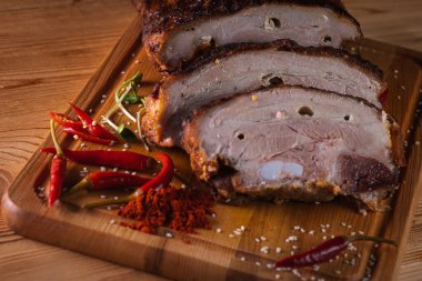 Üst manzara, lezzetli, sulu ve güzel kokulu domuz eti, koyu bir arka planda tahta bir tahtada pirzola, acı kırmızı biber ve baharatlar. Lezzetli et konsepti