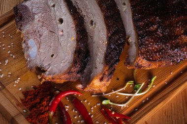 Üst manzara, lezzetli, sulu ve güzel kokulu domuz eti, koyu bir arka planda tahta bir tahtada pirzola, acı kırmızı biber ve baharatlar. Lezzetli et konsepti