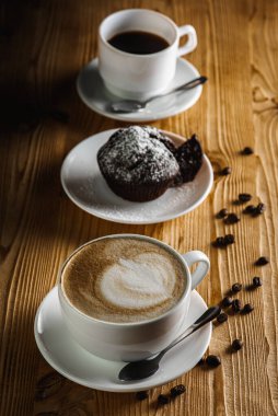 Klasik espresso, kahve parçalı kek ve kahve çekirdekleri eski ahşap bir masada. Sabah kahvesi. Üst görünüm.