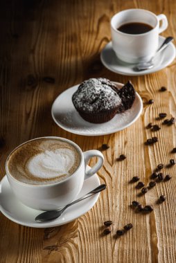 Klasik espresso, kahve parçalı kek ve kahve çekirdekleri eski ahşap bir masada. Sabah kahvesi. Üst görünüm.