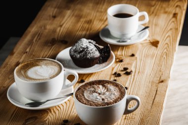 Klasik espresso, kahve parçalı kek ve kahve çekirdekleri eski ahşap bir masada. Sabah kahvesi. Üst görünüm.