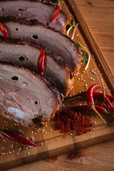 Lezzetli, sulu ve güzel kokulu domuz eti, siyah arka planda ahşap bir tahtada pirzola, acı kırmızı biber ve baharatlar. Lezzetli et konsepti