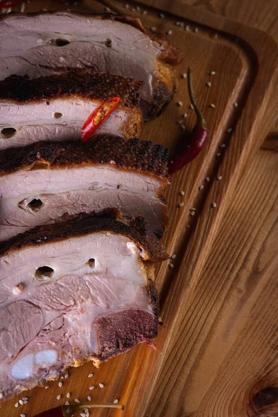 Lezzetli, sulu ve güzel kokulu domuz eti, siyah arka planda ahşap bir tahtada pirzola, acı kırmızı biber ve baharatlar. Lezzetli et konsepti