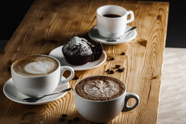 Klasik espresso, kahve parçalı kek ve kahve çekirdekleri eski ahşap bir masada. Sabah kahvesi. Üst görünüm.