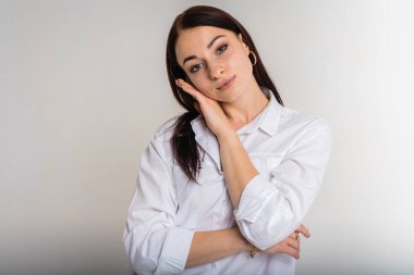 Kapalı portre, genç, hoş, çekici, sevimli, neşeli kolları açık beyaz renkli arka plan üzerinde izole edilmiş güzel kız.