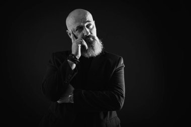 Sakallı, gülümseyen bir iş adamı. Elleriyle işaret ediyor. Bir şey gösteriyor. Alçakgönüllülük. Portre çok duygusal.