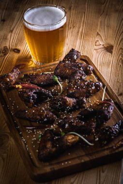 Bir bardak bira ve ahşap bir yüzeyde kızarmış tavuk bacağı. Üst Manzara. Seçici odaklanma. Lezzetli et yemeği. 