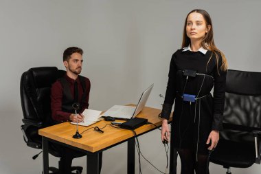 Konsantre, düşünceli bir kadın aydınlık bir odada, bir bilgisayar yalan makinesi üzerinde deneme yapıyor. Masada oturan genç adam yalan makinesi ve yalan makinesi monitörüne bakıyor. Doğruluk kavramı, yalan makinesi.