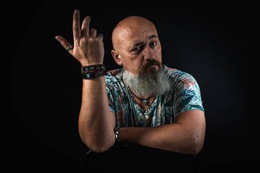 Yakın plan, duygusal, düşünceli, yakışıklı, sakallı bir iş adamının portresi. Alçak tuş koyu arkaplanda izole edildi. Vücut dili