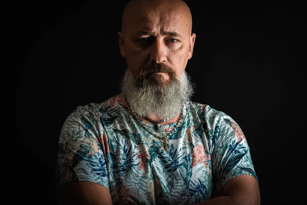 Yakın plan, duygusal, düşünceli, yakışıklı, sakallı bir iş adamının portresi. Alçak tuş koyu arkaplanda izole edildi. Vücut dili 