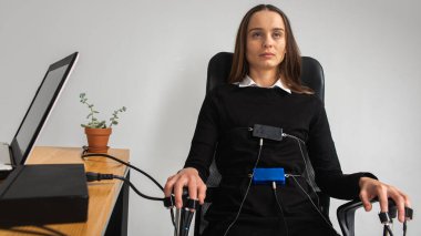 Konsantre, düşünceli, güzel kız, parlak bir odada, yalan makinesi testinde. Kız yalan makinesinin geçişi için sensör takıyor, sandalyede oturuyor. Doğruluk kavramı, yalan makinesi.