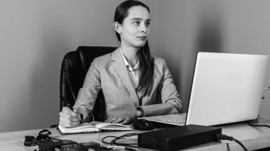 Evde bilgisayarla çalışan mutlu ve serbest bir genç kadın. Çevrimiçi öğrenim gören çekici iş kadını, dizüstü bilgisayar, web sörfü bilgileri veya internet mağazasından alışveriş yapıyor..