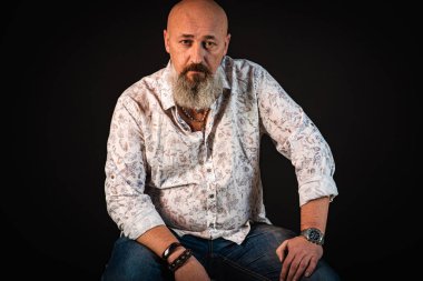 Yakın plan, duygusal, düşünceli, yakışıklı, sakallı genç iş adamının portresi. Alçak tuş koyu arkaplanda izole edildi. Vücut dili