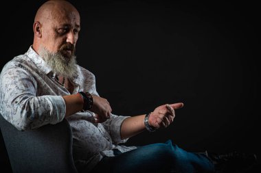 Yakın plan, duygusal, düşünceli, yakışıklı, sakallı genç iş adamının portresi. Alçak tuş koyu arkaplanda izole edildi. Vücut dili