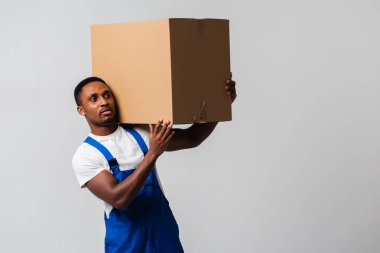 Karton kutulu bir kurye, mavi tulumlu genç bir Afro-Amerikalı ve beyaz tişörtlü karton kutu taşıyan bir adam. Beyaz bir arka planda izole edilmiş. Teslimat, posta, sevkiyat, forklift konsepti