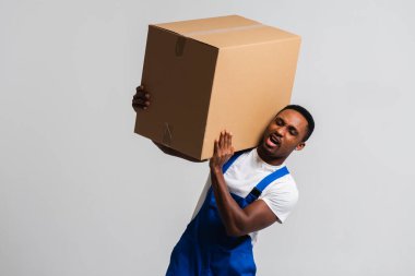 Karton kutulu bir kurye, mavi tulumlu genç bir Afro-Amerikalı ve beyaz tişörtlü karton kutu taşıyan bir adam. Beyaz bir arka planda izole edilmiş. Teslimat, posta, sevkiyat, forklift konsepti