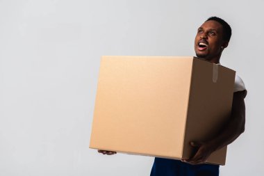 Karton kutulu bir kurye, mavi tulumlu genç bir Afro-Amerikalı ve beyaz tişörtlü karton kutu taşıyan bir adam. Beyaz bir arka planda izole edilmiş. Teslimat, posta, sevkiyat, forklift konsepti