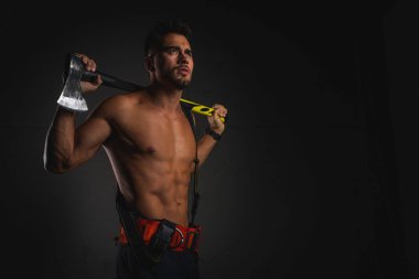 Kas yığını, üniformalı yakışıklı bir itfaiyecinin portresi. Karanlık bir arka planda, elinde yangın kaskı, elinde ıvır zıvır, başka tarafa bakıyor. Dikkat çekmeyen, seçici odaklanma. İtfaiyecilik mesleği.