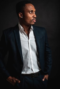 Çekici, güzel, ciddi ve stil sahibi Afro-Amerikan iş kadınının portresi koyu renkli arka planda izole edilmiş beyaz gömlek. Alçakgönüllülük. Seçici odak