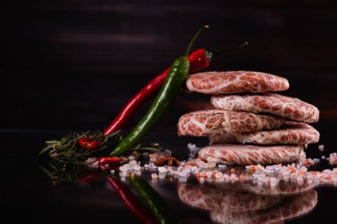 Koyu arkaplanda çiğ pirzola ile hamburger. Alçakgönüllülük. Etoburlar, et yemekleri. Seçici odak