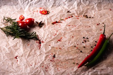Assorted peppers and spices on a light parchment background. Seasonings for food. Homemade spices ingredients for cooking. Selective focus