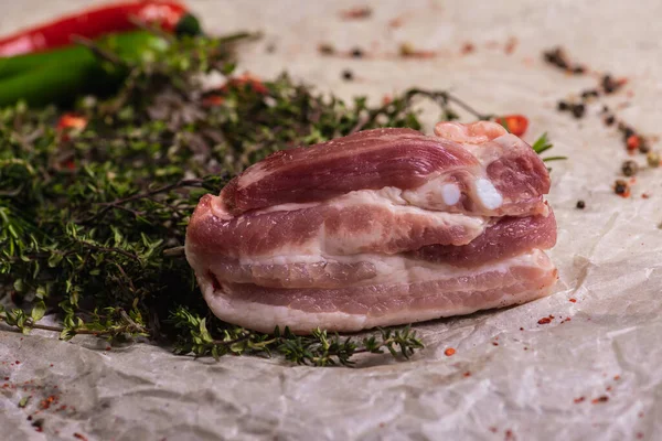 Raw fresh beef ribs steak with seasoning on a light surface, parchment, before cooking. Seasoning for meat steak with ribs for eyes rosemary, coriander, pepper. Top view, lying flat