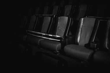 Sinema salonundaki kırmızı sandalyeler bir ışık demeti, basit bir anahtar, kısıtlayıcı bir bant ve karantina ile aydınlatılır. Seçici odaklanma. Boş sinema, COVID 19 karantinası, SARS-CoV-2, 2019-NCoV