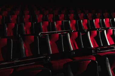 Boş sinema salonu. Sinema salonundaki koltuklar kırmızı ve siyah ışık huzmeleriyle aydınlatılır. Seçici odaklanma. Karantina, sandalyelerde kısıtlayıcı bant