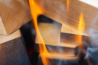 Ateş yakmak, ateş yakmak, bir sürü ağacın barbekü için hazır olduğu sıcak bir şömine yakmak, odun yakmak. Seçici odaklanma. Yakın görüş. Ateş kavramı, yanma.