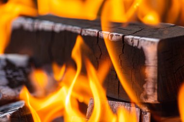 Ateş yakmak, ateş yakmak, bir sürü ağacın barbekü için hazır olduğu sıcak bir şömine yakmak, odun yakmak. Seçici odaklanma. Yakın görüş. Ateş kavramı, yanma.